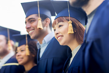 Image showing happy students or bachelors in mortar boards