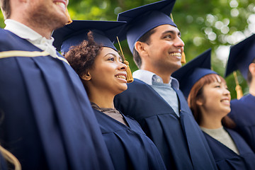 Image showing happy students or bachelors in mortar boards