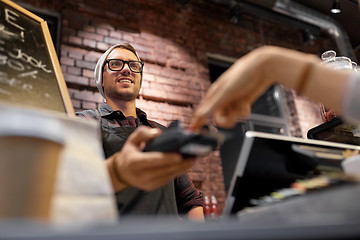 Image showing happy man with card-reader at bar or cafe