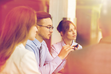 Image showing businessman texting on smartphone at office