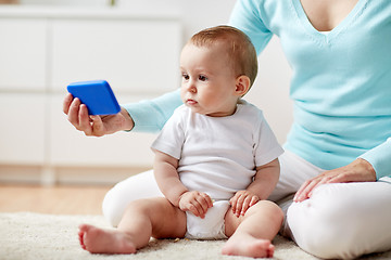 Image showing mother showing smartphone to baby at home