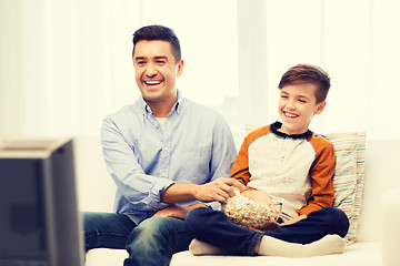 Image showing smiling father and son watching tv at home