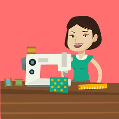 Image showing Seamstress using sewing machine at workshop.