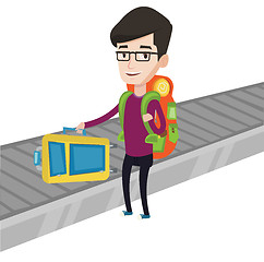 Image showing Man picking up suitcase on luggage conveyor belt.