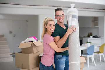 Image showing couple carrying a carpet moving in to new home