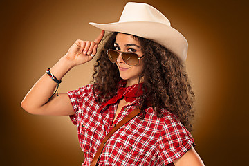 Image showing The cowgirl fashion woman over a brown background