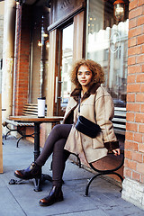 Image showing young pretty african american women drinking coffee outside in c