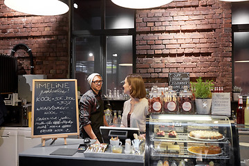 Image showing happy bartenders at cafe or coffee shop counter