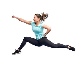 Image showing happy sporty young woman jumping in fighting pose