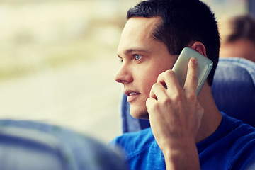 Image showing happy man in travel bus and calling on smartphone