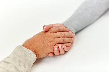 Image showing close up of old man and young woman holding hands