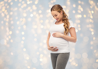 Image showing happy pregnant woman touching her big belly