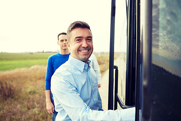 Image showing group of happy male passengers boarding travel bus