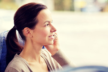 Image showing happy woman in travel bus calling on smartphone
