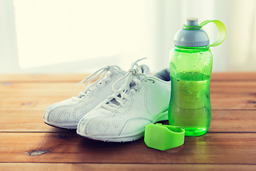 Image showing close up of sneakers, bracelet and water bottle