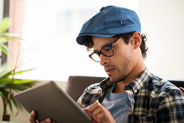 Image showing close up of man with tablet pc sitting at cafe