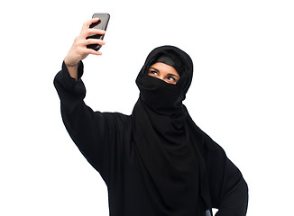 Image showing muslim woman in hijab taking selfie by smartphone