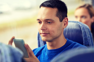 Image showing happy man sitting in travel bus with smartphone