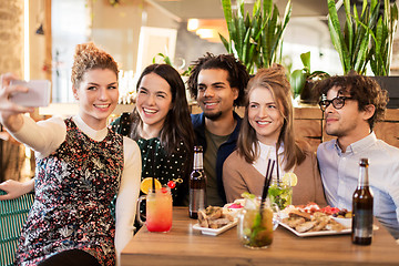 Image showing friends taking selfie by smartphone at bar or cafe