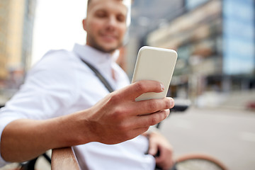 Image showing close up of man texting on smartphone in city