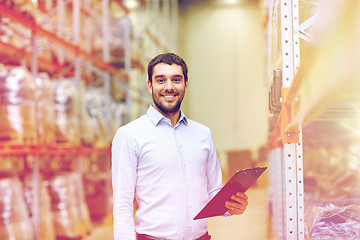 Image showing happy businessman with clipboard at warehouse