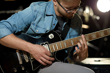 Image showing close up of man playing guitar at studio rehearsal