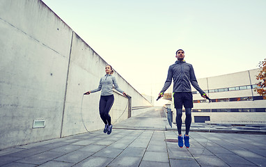 Image showing man and woman exercising with jump-rope outdoors