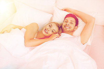 Image showing happy couple lying in bed at home