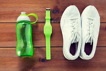 Image showing close up of sneakers, bracelet and water bottle