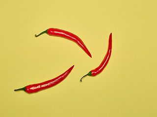 Image showing bitter chili pepper and paprika on a yellow background