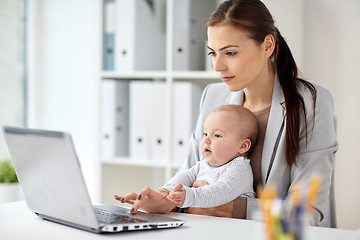 Image showing happy businesswoman with baby and laptop at office