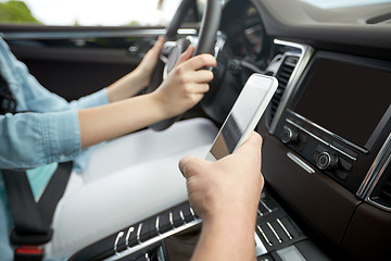 Image showing happy man and woman with smartphone driving in car