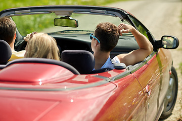 Image showing happy friends driving in convertible car at summer