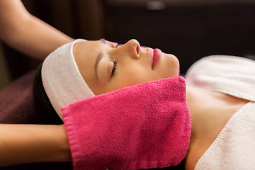 Image showing woman having face massage with terry gloves at spa