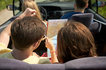 Image showing happy friends with map driving in convertible car