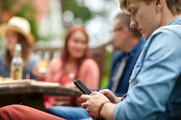 Image showing man with smartphone and friends at summer party