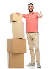 Image showing happy man with cardboard boxes showing thumbs up