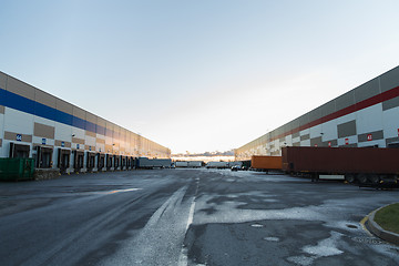 Image showing warehouse gates and trucks loading