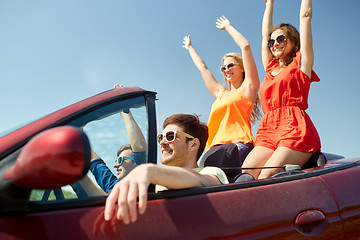 Image showing happy friends driving in cabriolet car at country