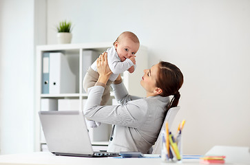 Image showing happy businesswoman with baby and laptop at office