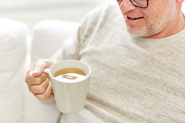 Image showing close up of happy senior man drinking tea at home