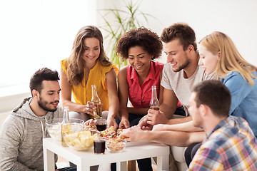 Image showing happy friends with drinks eating pizza at home