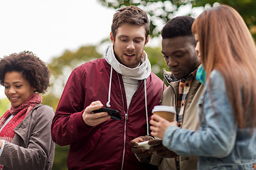 Image showing happy friends with smartphone and coffee outdoors