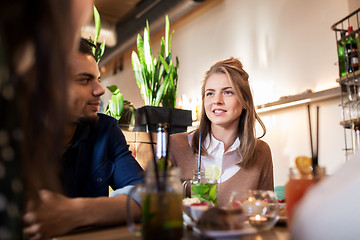 Image showing happy friends eating and drinking at restaurant