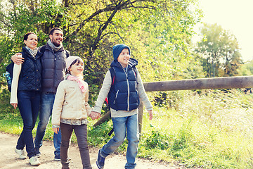 Image showing happy family with backpacks hiking in woods