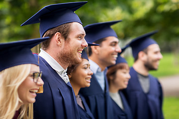 Image showing happy students or bachelors in mortar boards