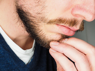 Image showing Male person, at closeup with fingers in beard