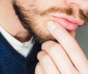 Image showing Male person, at closeup with fingers in beard