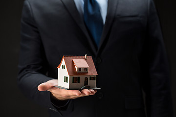 Image showing close up of businessman holding house model