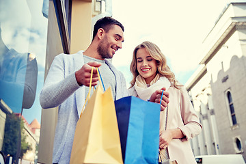 Image showing happy couple with shopping bags at shop window